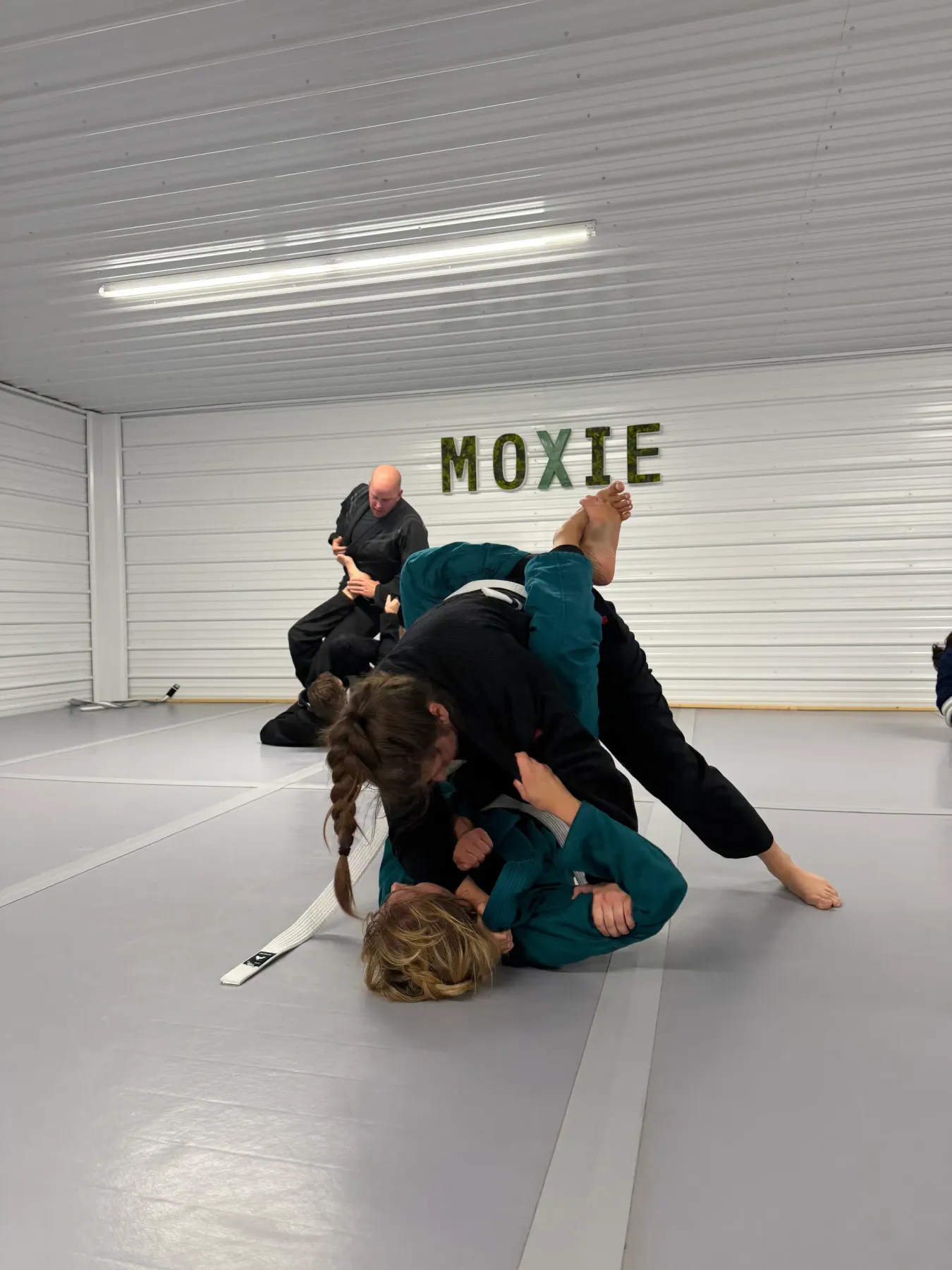 Students of ordinary skill levels train together on the mats inside the Moxie Jiu Jitsu academy.